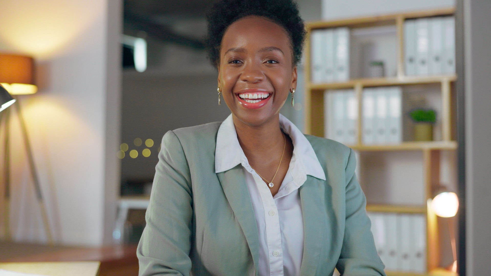 Retrato, oficina y mujer negra con una sonrisa, agente de negocios y seguros con una carrera, startup y emprendedora. Enfréntate a una persona o empleado africano en un lugar de trabajo, misión y ambición con éxito